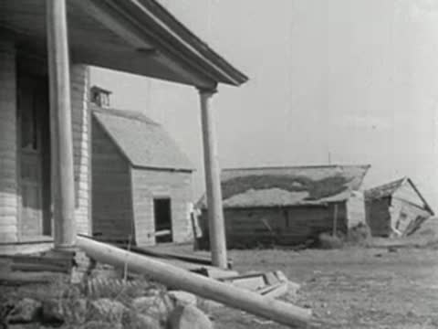View of small farm buildings and a porch structure in the countryside
