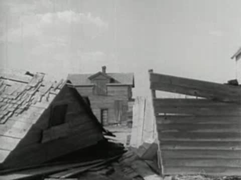 Damaged and collapsed wooden farm structures and fences on the prairie