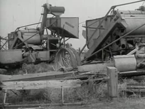 Agricultural machinery operating in a field, vintage black and white film style.