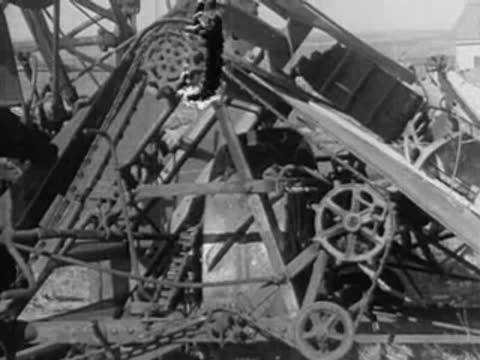 Close-up of mechanical gears and pulleys on an old farm machine.