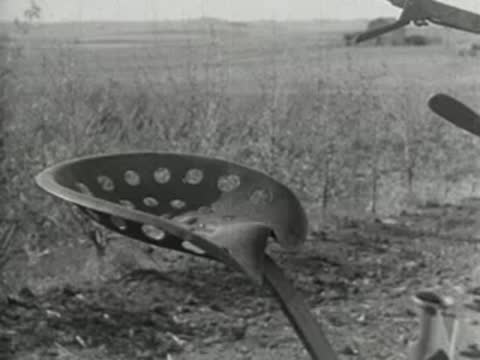 Close-up of a metal tractor seat in a rural field.