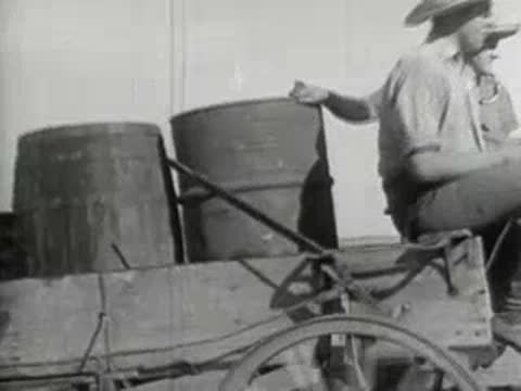 Two people riding in a horse-drawn cart across the plains, historical documentary