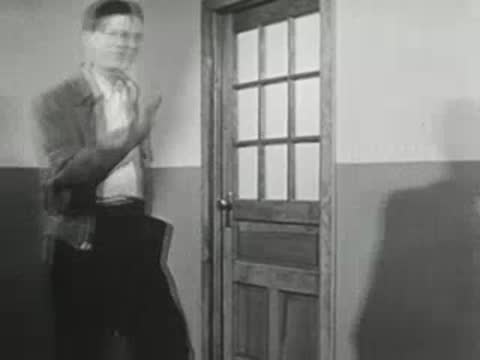 Student walking through doorway in school hallway.