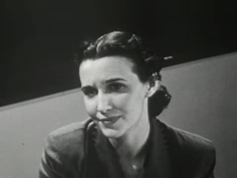 Close-up of a female teacher talking while sitting at her desk
