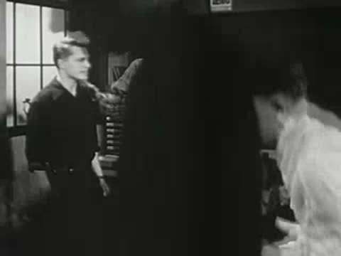 A young man walking across a classroom towards students