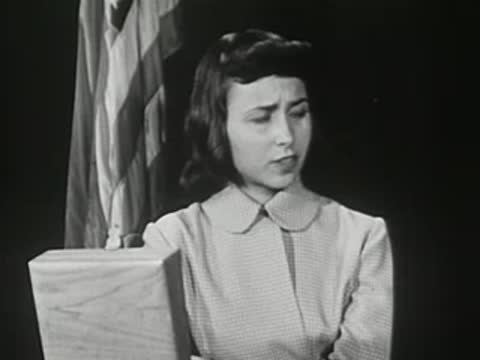 Close-up of a female student holding a book in an auditorium