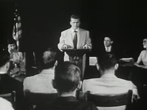 A young man speaking at a podium in front of an American flag