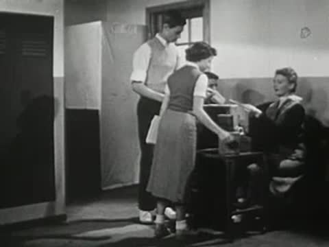Students working and moving around a desk in a hallway