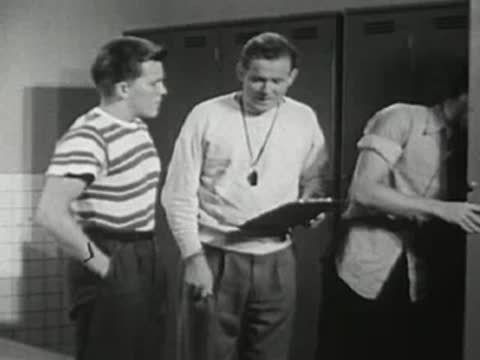 Coach talking to students in the locker room.