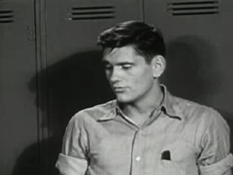 Close-up of teen boy listening in the locker room.