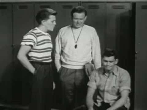 Students sitting on benches in the locker room.