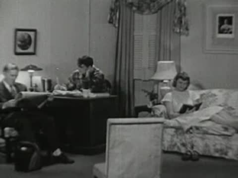 Transition to a home living room with a father reading and son studying.