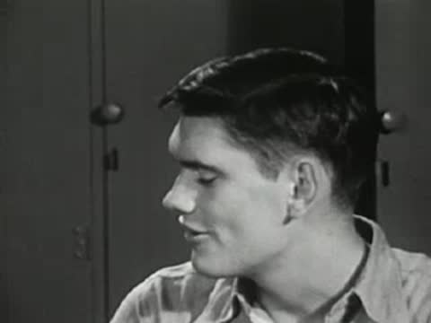 Medium shot of a young man looking to the side and talking.