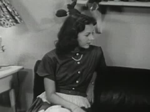 Young woman sitting on a couch, looking to the side.