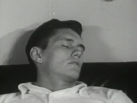 Young man sleeping peacefully lying on a couch.