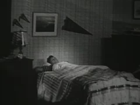 Boy sleeping in a bed inside a bedroom at night.