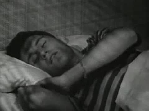 Boy tossing and turning in bed, restless sleep.
