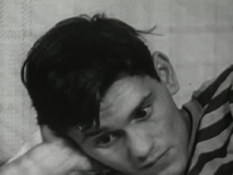Close-up of the teenager waking up and squinting against the light.