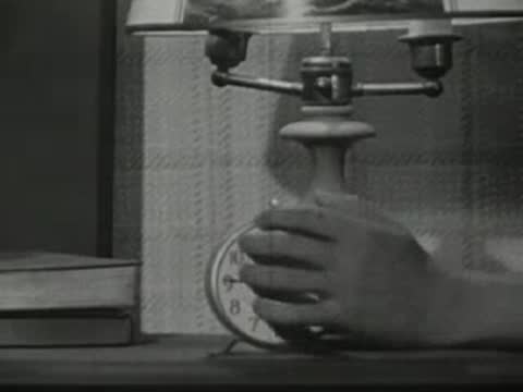 Close-up of an alarm clock on a nightstand as a hand turns it off.
