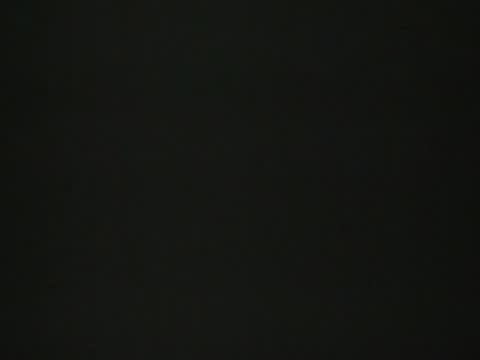 A brief, dark, or mostly black frame showing two athletes standing in the locker room.