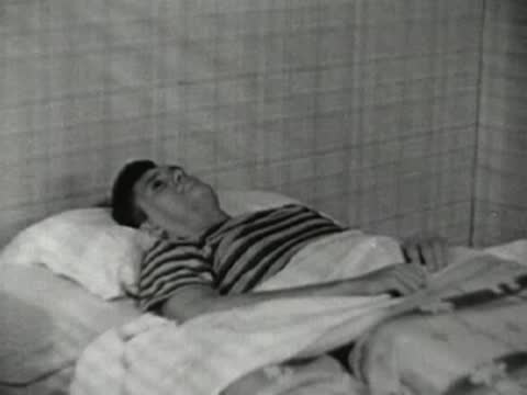 The teenager lies down in bed, settling in for sleep.