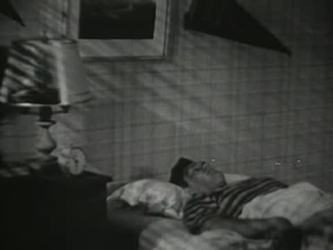 The teenager rests in bed under the covers at night.