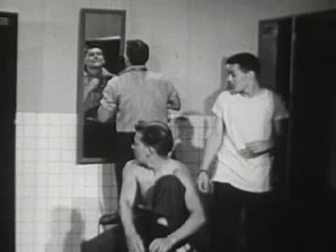 Young men change clothes in a locker room.
