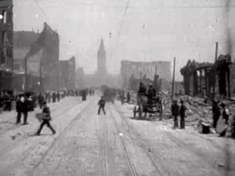 Pedestrians walking along a debris-lined street in post-earthquake San Francisco.