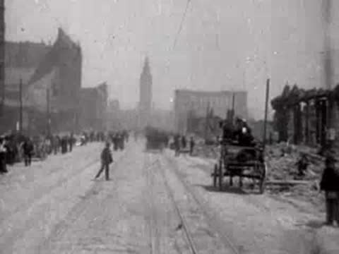 A horse-drawn wagon and pedestrians traveling down a destroyed city street.