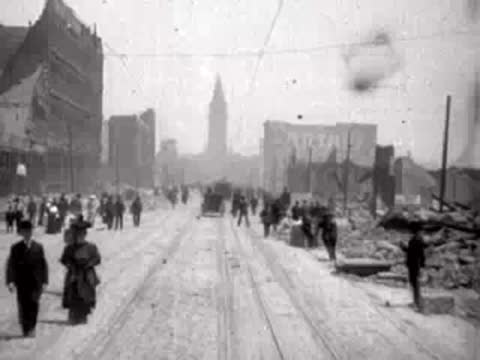 People walking down the middle of a ruined San Francisco street toward the camera.