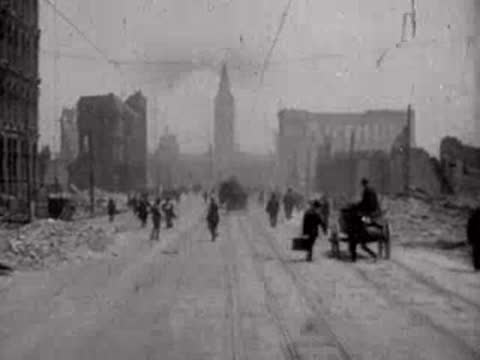 Pedestrians and a horse-drawn cart moving along a ruined city street.