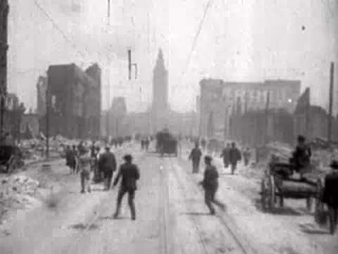 People walking past a horse-drawn carriage on a ruined city street.