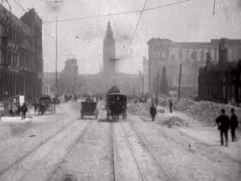 Pedestrians and a horse-drawn carriage moving along a ruined street.