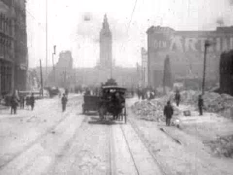 A horse-drawn carriage traveling down a ruined city street with pedestrians.