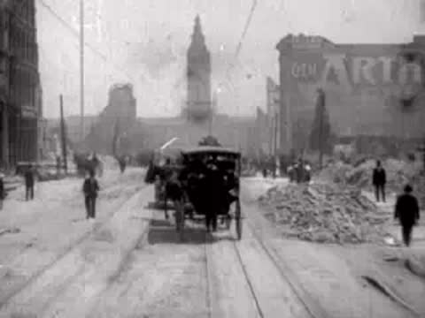Horse-drawn carriage driving forward on a ruined street past pedestrians.