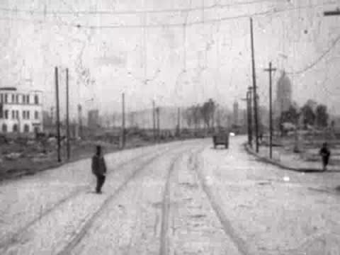 A person walking across a wide, cleared road with distant dome architecture.