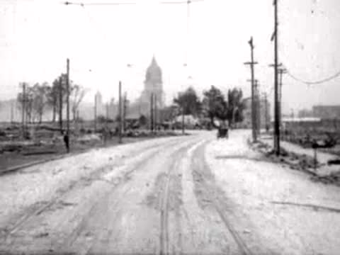 Road curving toward a distant domed structure amidst cleared surroundings.