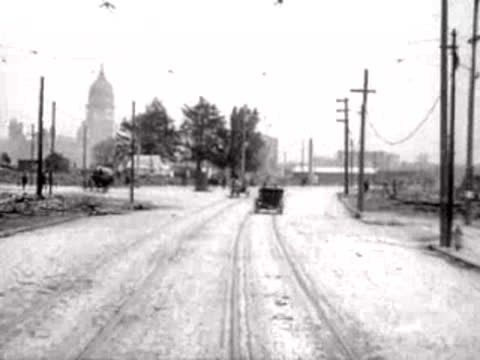 View down a road leading to a distant city skyline with a dome.