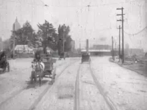Looking forward from a moving tram down a San Francisco street, historical footage.