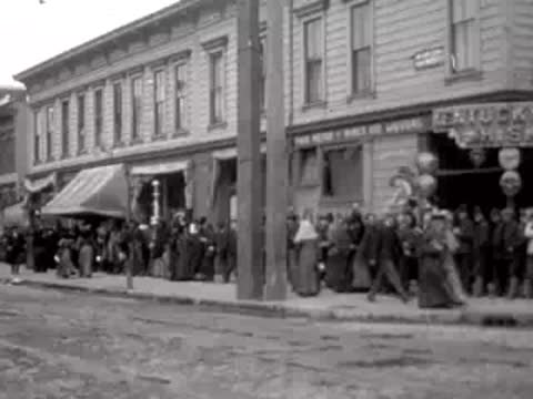 Crowd gathered in front of a building on a San Francisco street in 1906.