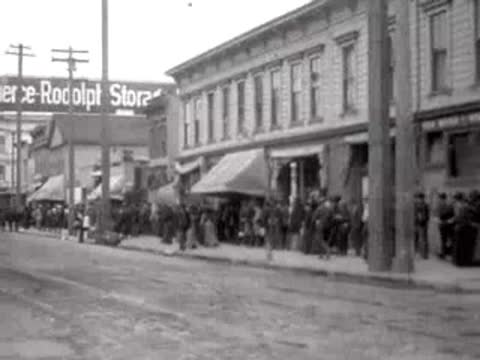 Crowd gathered outside a building named Pierce Rudolph Storage in San Francisco, 1906.