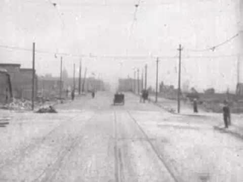 distant carriage on road with scattered debris, historical footage