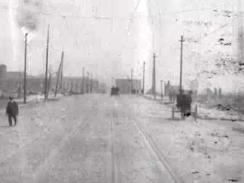 pedestrian walking along wide damaged road, historical footage