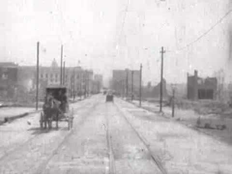 horse-drawn carriage moving toward camera on street, historical footage