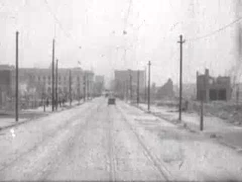 horse-drawn carriage passing camera on wide street, historical footage