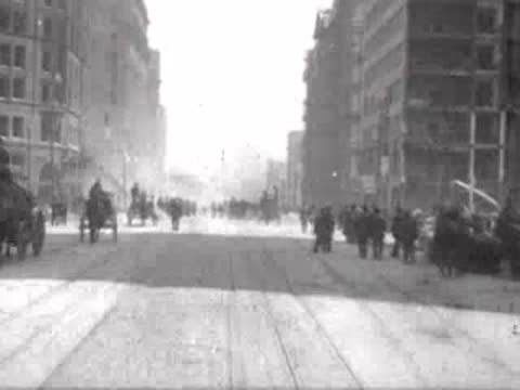 crowds of people on street between damaged buildings, historical footage