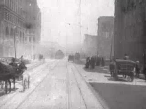 Street view after San Francisco earthquake, horse carriage, rubble, pedestrians.