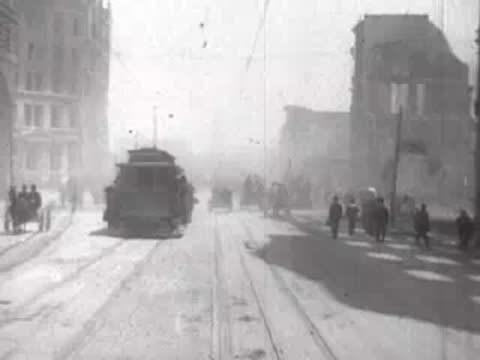 Street view after San Francisco earthquake, approaching cable car, pedestrians, rubble.
