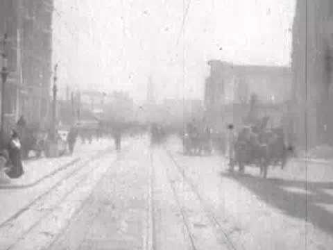 Street view after San Francisco earthquake, horses, horse-drawn carts, debris, pedestrians.