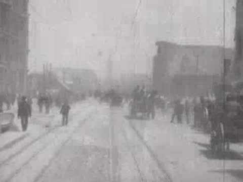 Street view after San Francisco earthquake, horse-drawn carts, debris, pedestrians.